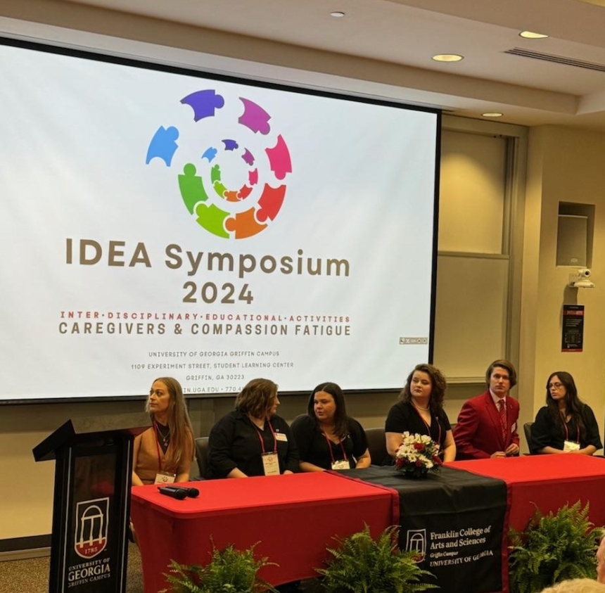 IDEA Symposium with presenters sitting at a table